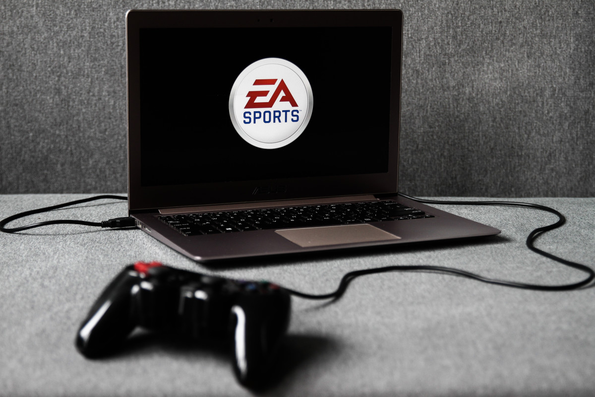 EA Sports logo displayed on a laptop screen and a gamepad are seen in this illustration photo taken in Krakow, Poland on August 5, 2021. (Photo by Jakub Porzycki/NurPhoto via Getty Images)