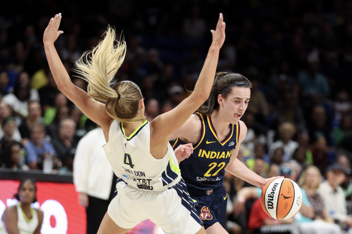 ARLINGTON, TEXAS - MAY 03: Caitlin Clark #22 of the Indiana Fever drives to the basket against Jacy Sheldon #4 of the Dallas Wings during the first quarter in the preseason game at College Park Center on May 03, 2024 in Arlington, Texas.  (Photo by Gregory Shamus/Getty Images)