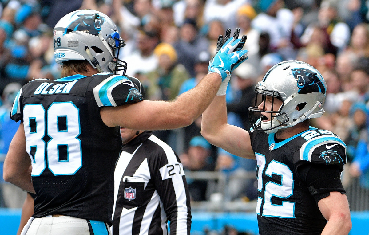 CHARLOTTE, NC - DECEMBER 17: Christian McCaffrey #22 celebrates with teammate Greg Olsen #88 of the Carolina Panthers after a touchdown against the Green Bay Packers in the first quarter during their game at Bank of America Stadium on December 17, 2017 in Charlotte, North Carolina. (Photo by Grant Halverson/Getty Images)