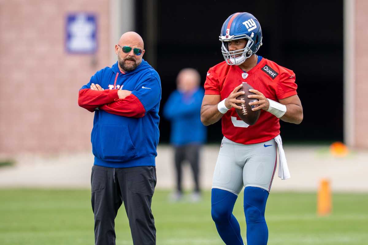 Russell Wilson and Brian Daboll talk during practice.