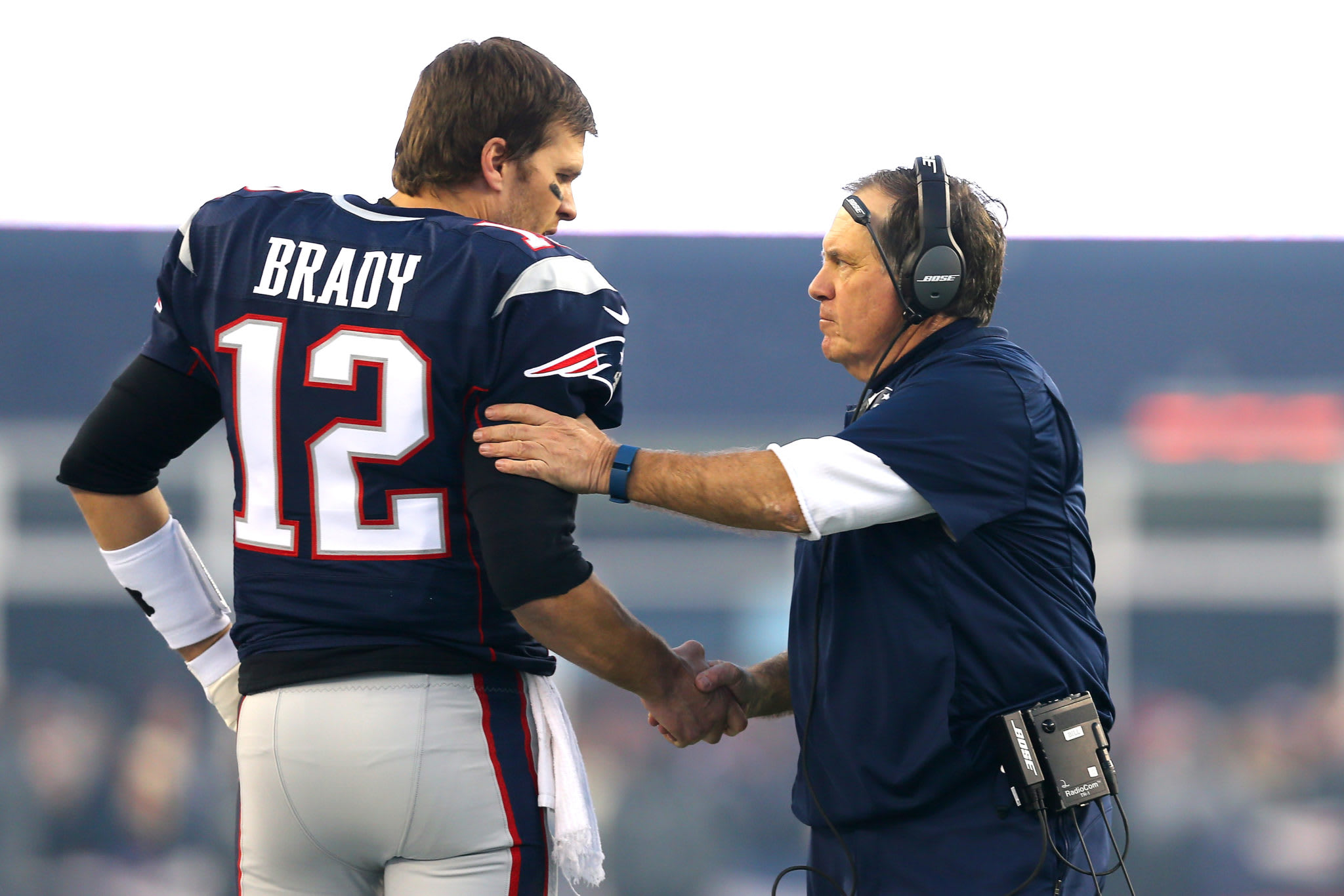 Tom Brady talking to Bill Belichick.