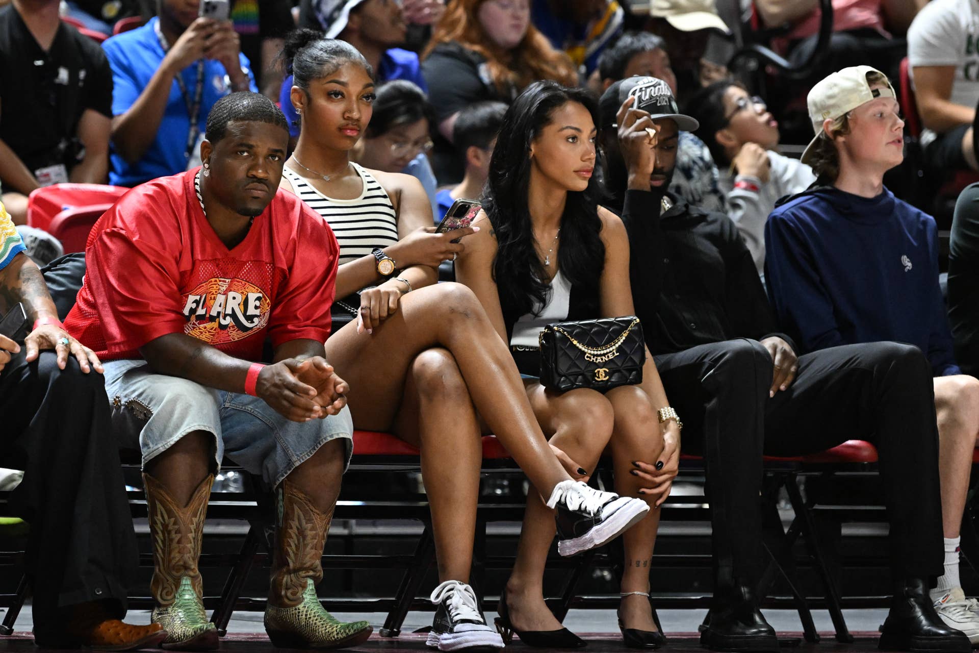 Angel Reese courtside with Kysre Gondrezick and Jaylen Brown.
